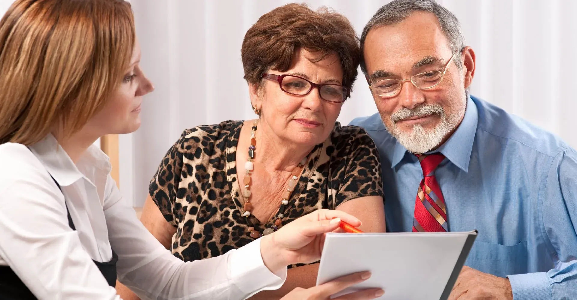 Conseillère présentant un document officiel à un couple d'ainés.